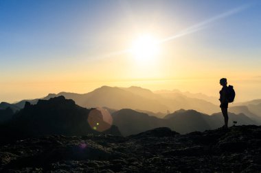 Kadın siluet dağlar, gün batımı ve okyanus hiking. Güzel ilham verici manzaraya, gün batımı ilham verici manzara seyir kadın uzun yürüyüşe çıkan kimse.