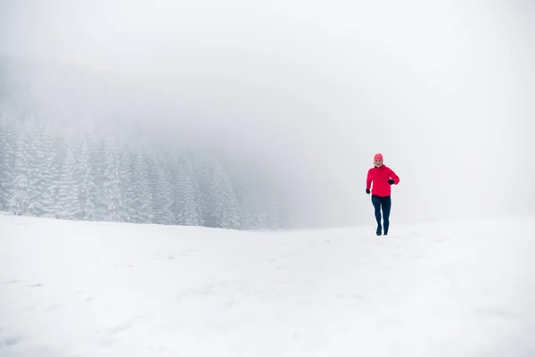 冬天的山上 女孩在雪地上奔跑 健身的灵感和动力 年轻快乐的女子足迹在高山上奔跑 在雪地上 冬日里 女性小道跑步者在户外跑步 — 图库照片