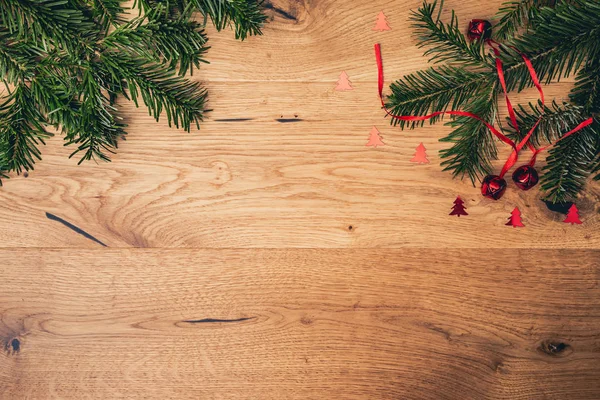 クリスマス背景もみ木 赤い光沢のある鐘と茶色の木製のテーブル コピー スペースを持つトップ フラット ビュー ロイヤリティフリーのストック画像