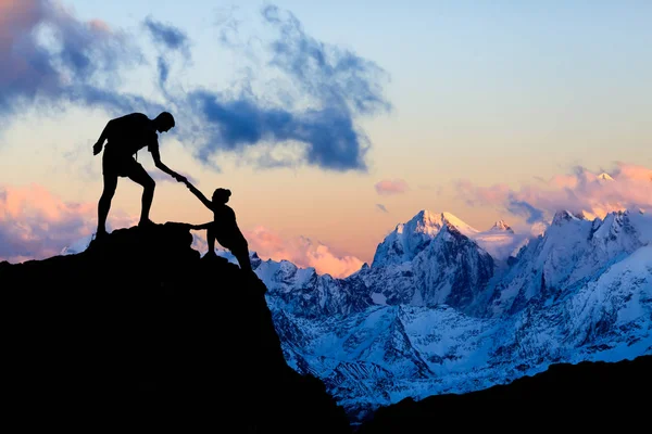 Teamwork couple helping hand, trust in mountains — Stock Photo, Image