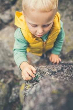 Bir kaya üzerinde oynayan toddler çocuk