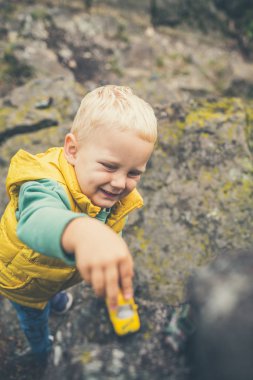 Bir kaya üzerinde oynayan toddler çocuk