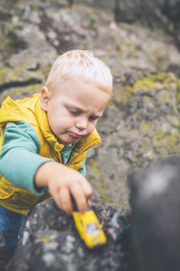 Bir kaya üzerinde oynayan toddler çocuk