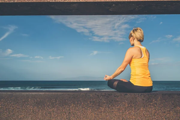 Yoga-kız meditasyon ve yoga poz, okyanus manzarası rahatlatıcı — Stok fotoğraf