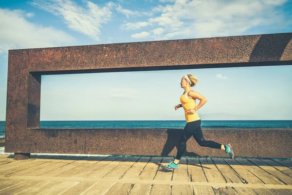 Mujer joven corriendo en las montañas en el soleado día de verano —  Fotos de Stock