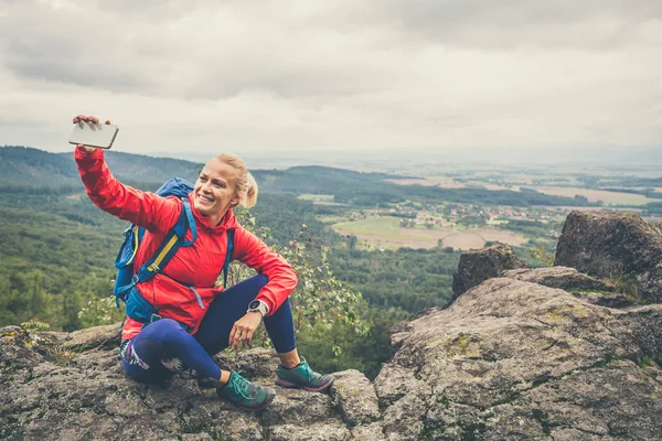Kadın fotoğrafı ile smartphone çekmek sırt çantası ile hiking — Stok fotoğraf