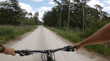 Yeşil çam ormanlarındaki toprak yolda bisiklet sürerken. Birinci şahıs bakış açısından bak Pov. 4k titreşim sabitleyici video, Gopro Kahraman 7 siyah.