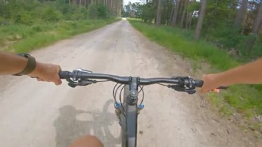 Yeşil tarlalar arasında kayalık yolda çakıllı dağ bisikleti sürmek. Birinci şahıs bakış açısından bak Pov. 4k titreşim sabitleyici video, Gopro Kahraman 7 siyah.