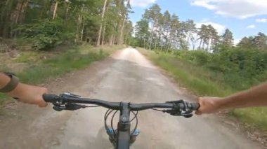 Yeşil tarlalar arasında kayalık yolda Enduro dağ bisikleti sürmek. Birinci şahıs bakış açısından bak Pov. 4k titreşim sabitleyici video, Gopro Kahraman 7 siyah.