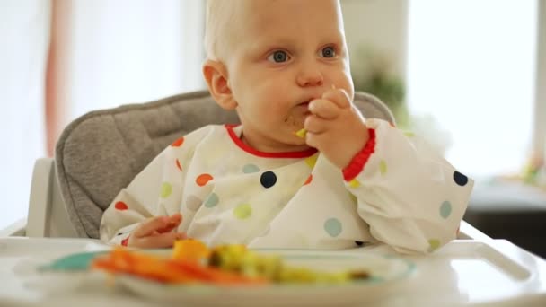 子供の食事ニンジンとブロッコリーを吹く方法で 赤ちゃん主導の機織り 幸せな菜食主義者の子供は昼食を食べる幼児は自分自身を食べます 自己給餌 — ストック動画