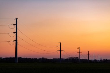 Elektrik kesintisi - gündoğumunda ya da günbatımında açık gökyüzünde elektrik hatlarının silueti.