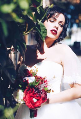 Beyaz gelinlikli güzel gelin dışarıda poz veriyor.