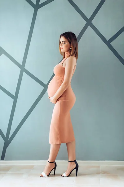 스튜디오에서 드레스에 임신한 여자의 초상화 — 스톡 사진