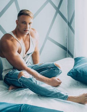 Güçlü sağlıklı yakışıklı atletik erkek yatakta poz portresi