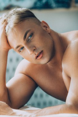 Güçlü sağlıklı yakışıklı atletik erkek yatakta poz portresi