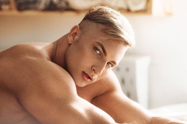 Güçlü sağlıklı yakışıklı atletik erkek yatakta poz portresi