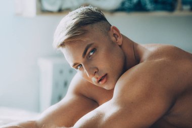 Güçlü sağlıklı yakışıklı atletik erkek yatakta poz portresi