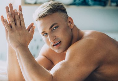 Güçlü sağlıklı yakışıklı atletik erkek yatakta poz portresi