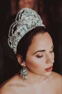 Güzel genç kadın stüdyoda poz taç 