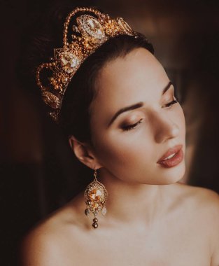 Güzel genç kadın stüdyoda poz taç 