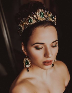 Güzel genç kadın stüdyoda poz taç 