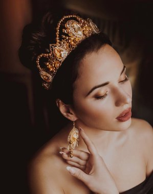 Güzel genç kadın stüdyoda poz taç 