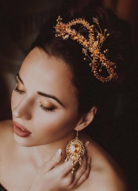 Güzel genç kadın stüdyoda poz taç 