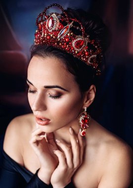 Güzel genç kadın stüdyoda poz taç 