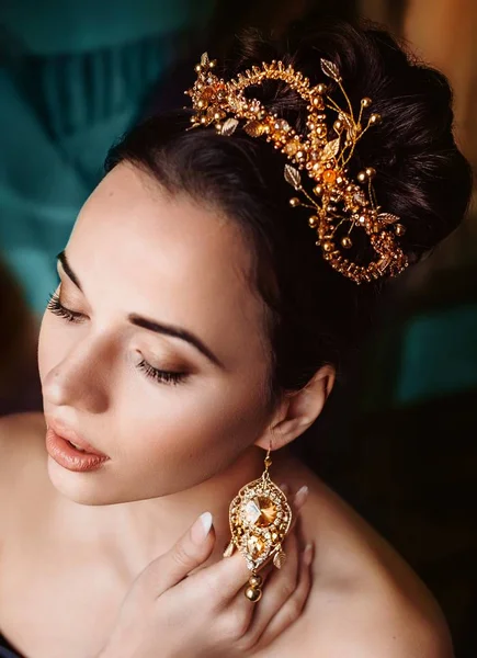 Güzel genç kadın stüdyoda poz taç 