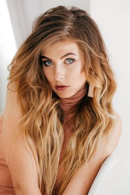 Güzel genç kadın elbise ve stüdyoda poz küpe 