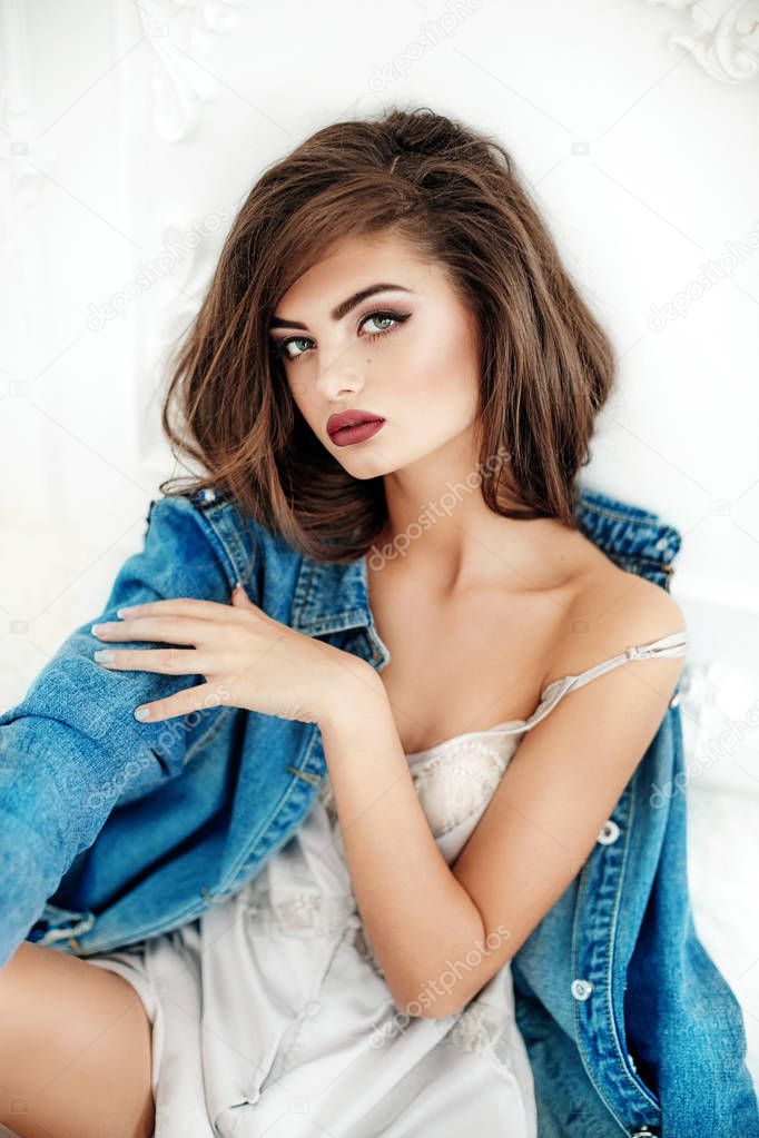 portrait of beautiful young brunette woman with makeup in fashion clothes