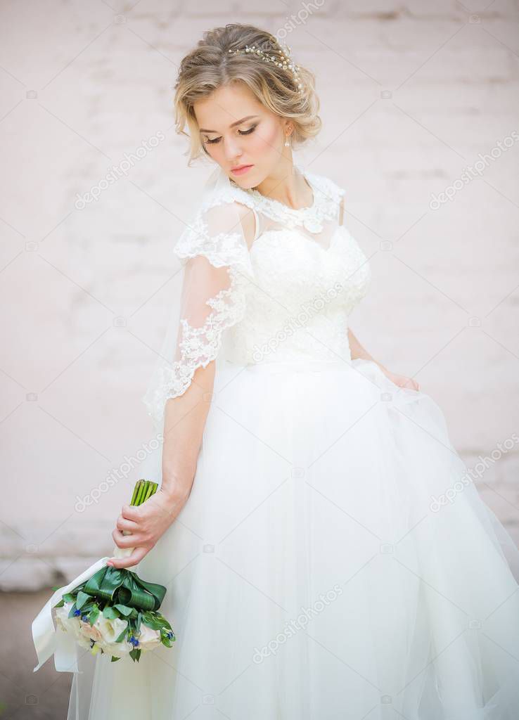 Beautiful young bride in white wedding dress posing 