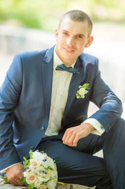 Yakışıklı damat gülümseyen ve gelin için bekliyor. Mutlu gülümseyen damat yeni evli. 