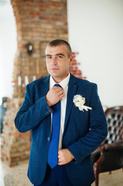 Yakışıklı damat gülümseyen ve gelin için bekliyor. Mutlu gülümseyen damat 