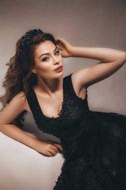 Studio poz siyah elbiseli güzel genç esmer kadın portresi