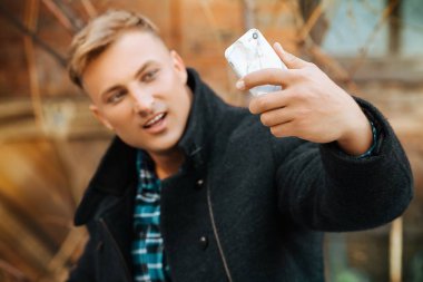 Yakışıklı delikanlı selfie yapıyor bir cep telefonu ile