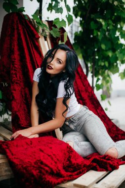 Kot pantolon kadife kumaş arka planı açık poz güzel genç esmer kadın portresi