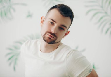 Beyaz t-shirt boğazlı kazak poz içinde şık adam