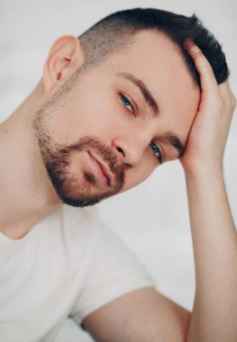 Beyaz t-shirt boğazlı kazak poz içinde şık adam