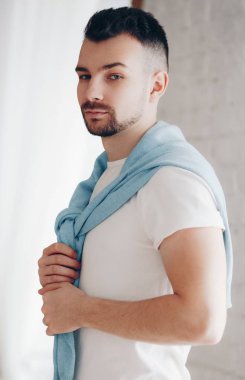 Beyaz t-shirt boğazlı kazak poz içinde şık adam