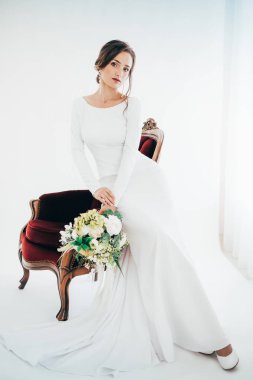 Güzel genç gelin çiçekleri ile poz beyaz gelinlik