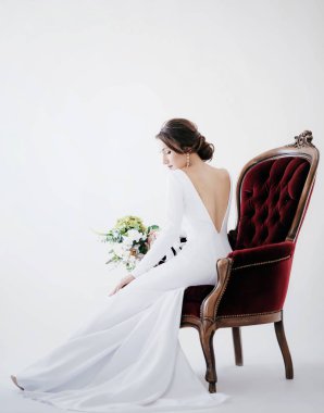 Güzel genç gelin çiçekleri ile poz beyaz gelinlik