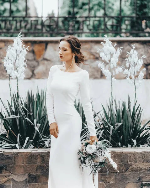 Krásná Mladá Nevěsta Bílých Svatebních Šatech Pózuje Květinami — Stock fotografie