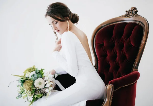 美丽的年轻新娘在白色婚纱摆姿势与花 — 图库照片
