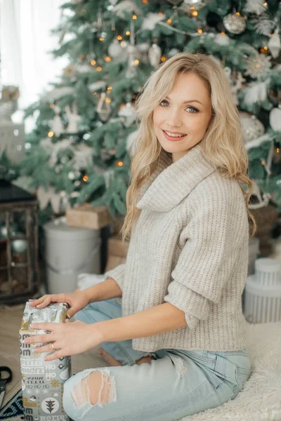 クリスマス ツリー ポーズ自宅近くのギフトと美しい女性 — ストック写真