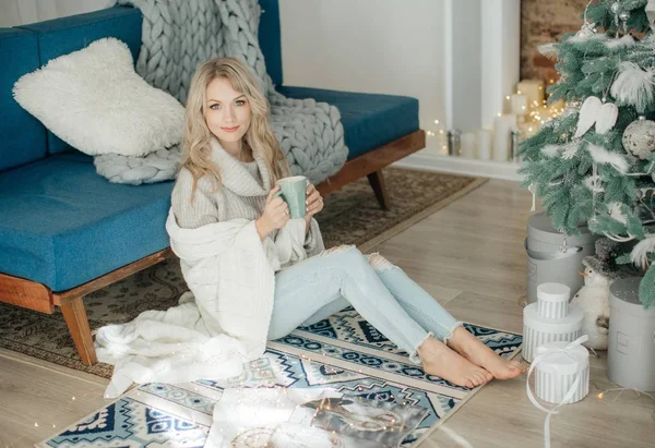 Mooie Vrouw Met Een Warme Drank Buurt Van Kerstboom Poseren — Stockfoto