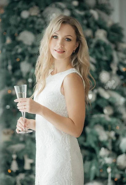 クリスマス ツリー シャンパン ポーズを自宅近くの赤いドレスで美しい女性 — ストック写真
