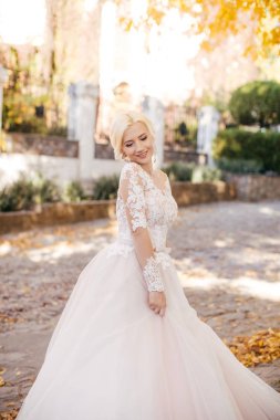 Parkta poz beyaz gelinlikle güzel genç gelin