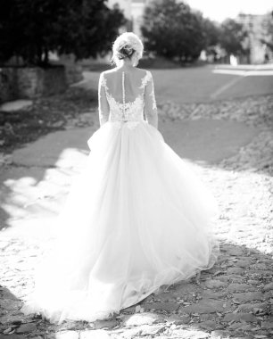 Parkta poz beyaz gelinlikle güzel genç gelin