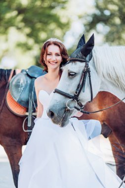 Atlarla açık poz beyaz gelinlikle güzel genç gelin